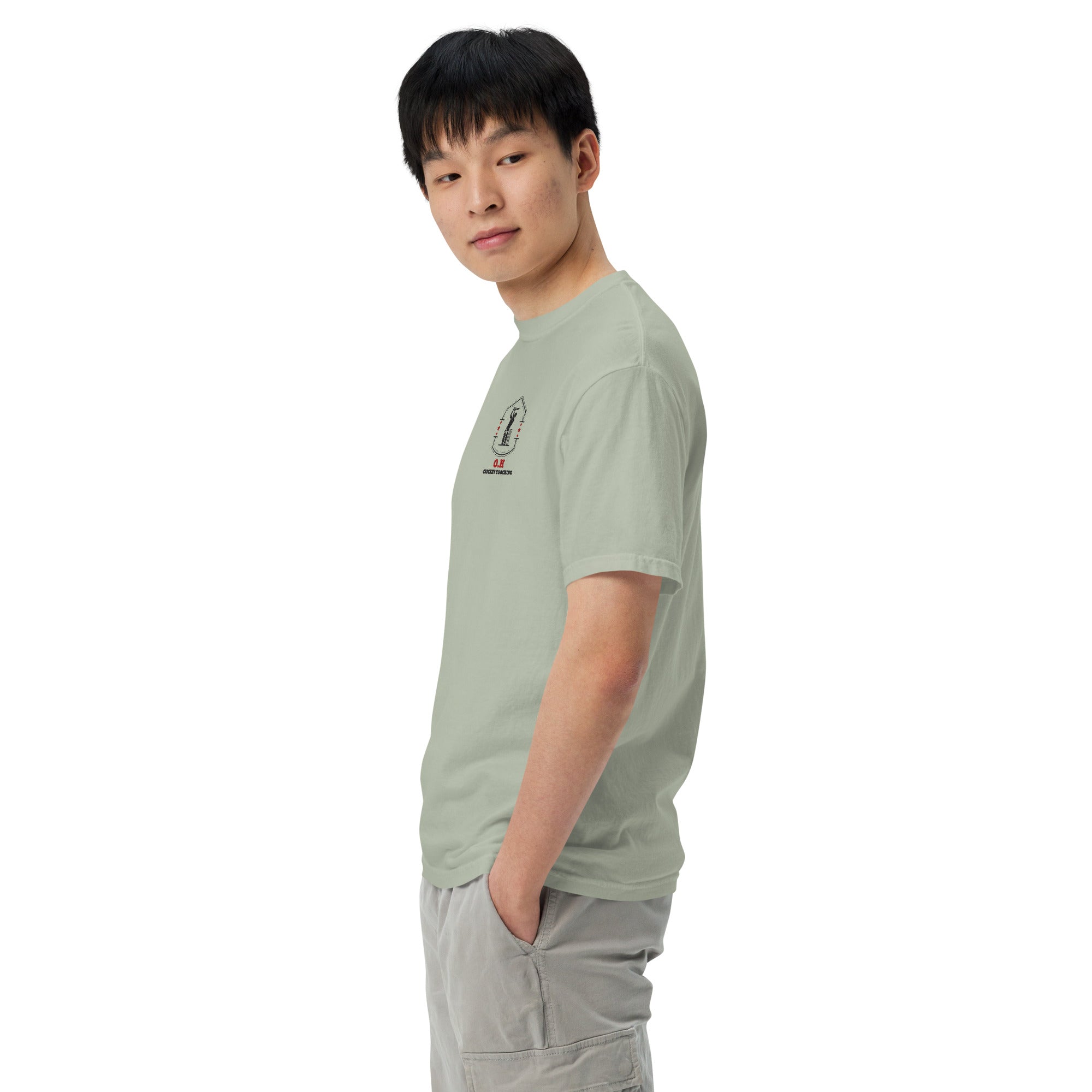 Person wearing a light green t-shirt with a small graphic on a white background