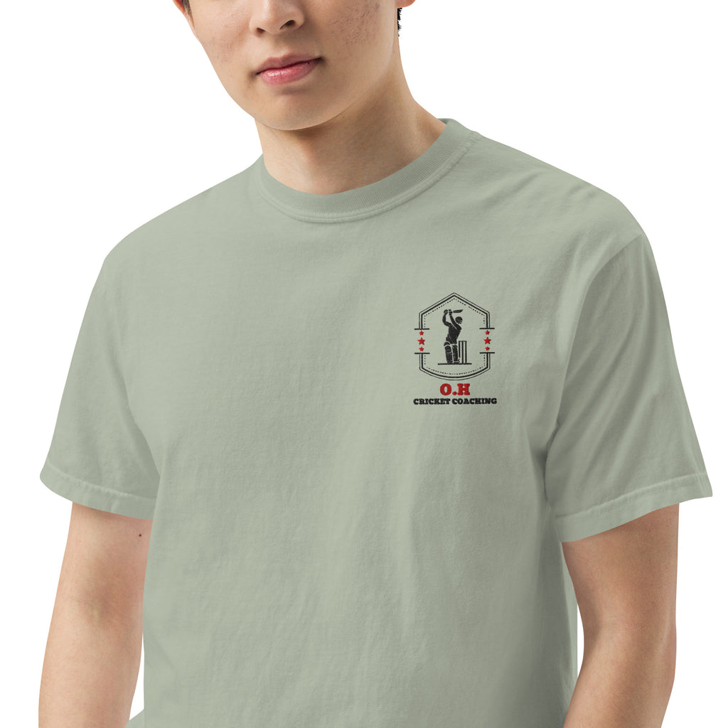 Person wearing a light green t-shirt with a logo on the chest