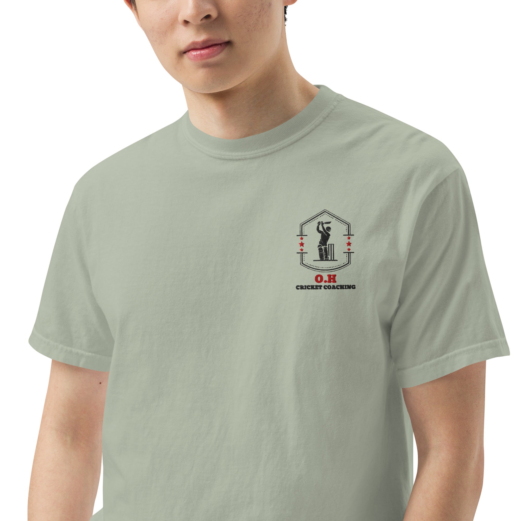 Person wearing a light green t-shirt with a logo on the chest