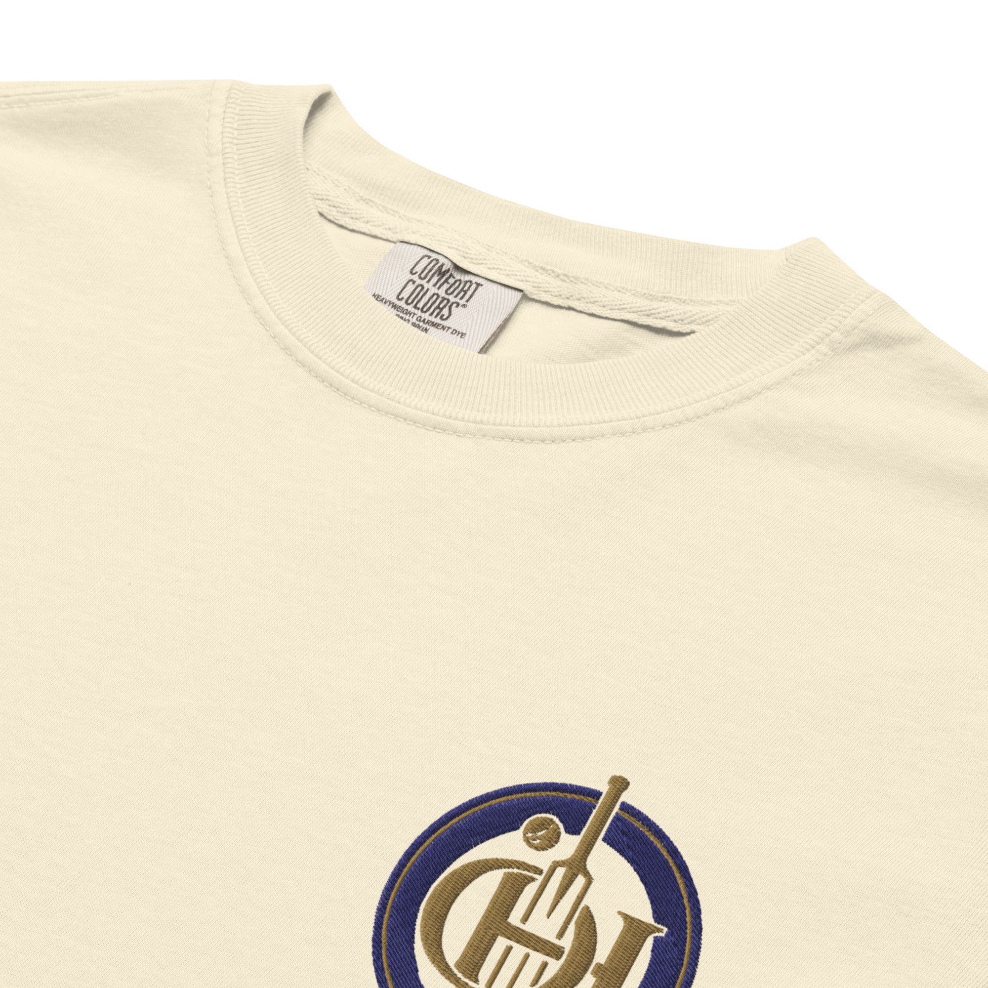 Close-up of a cream-colored Comfort Colors t-shirt and a partial circular graphic on the chest.