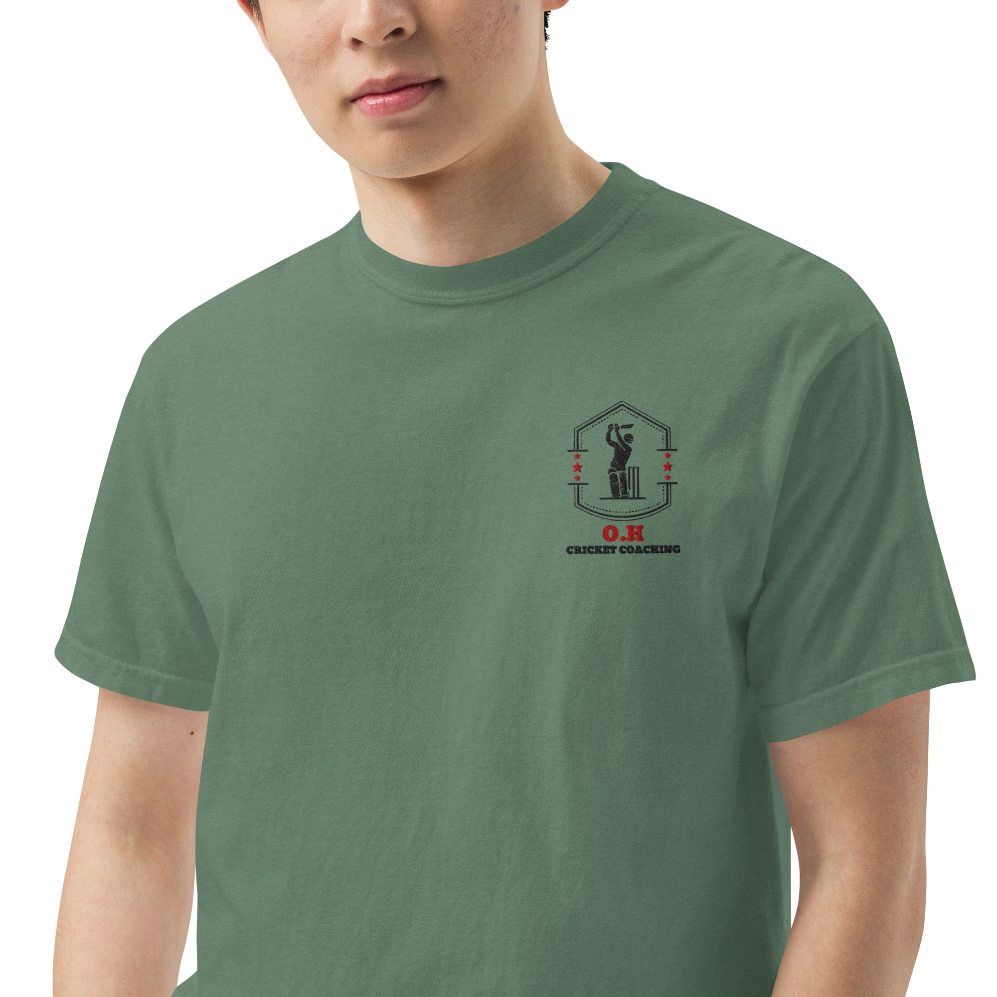 Person wearing a green t-shirt with a logo on the chest