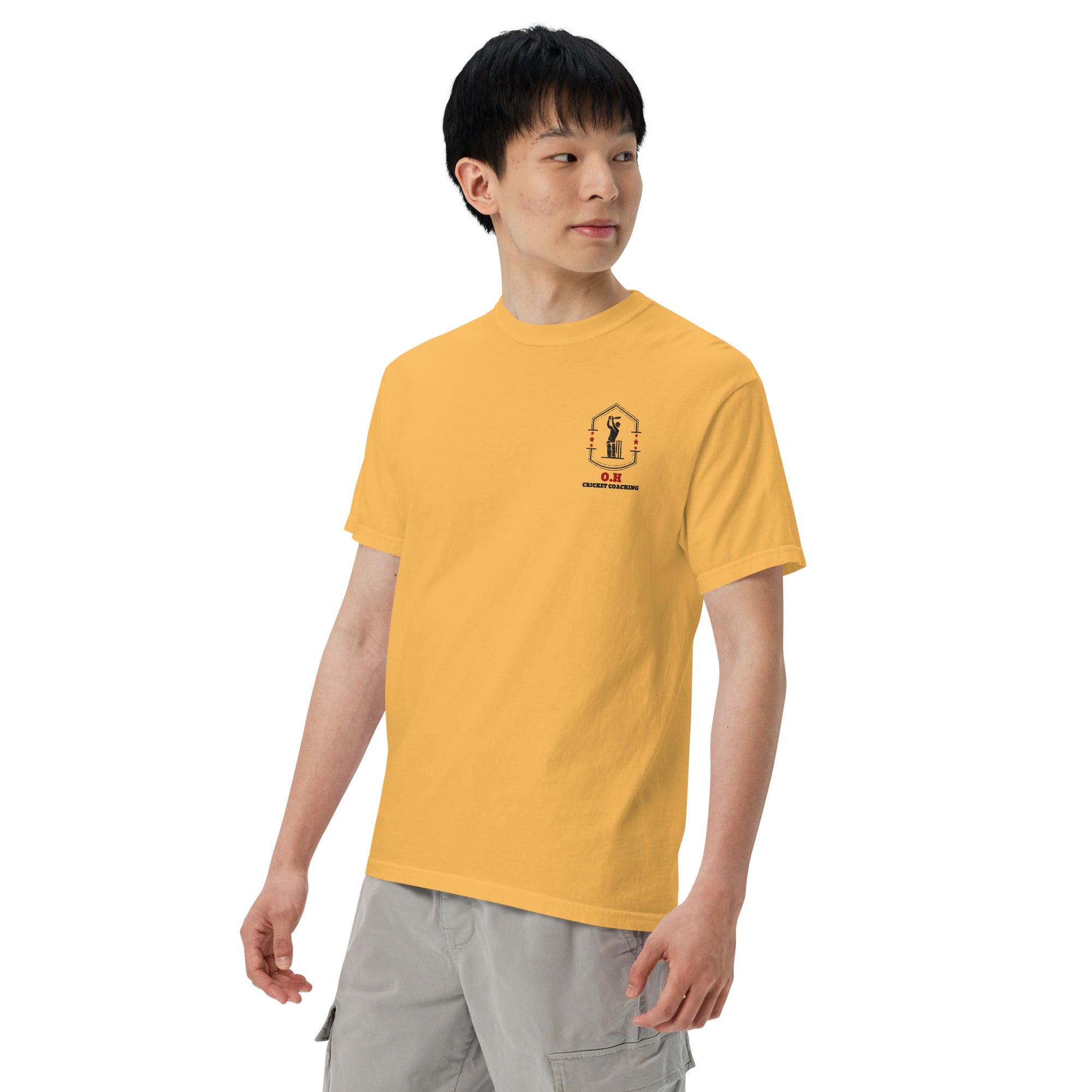 Person wearing a yellow t-shirt with a small logo on a white background