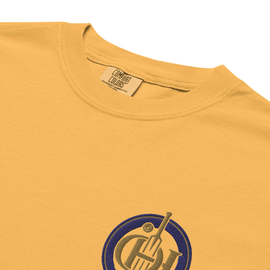 Close-up of a mustard yellow t-shirt with a circular graphic logo on the chest.