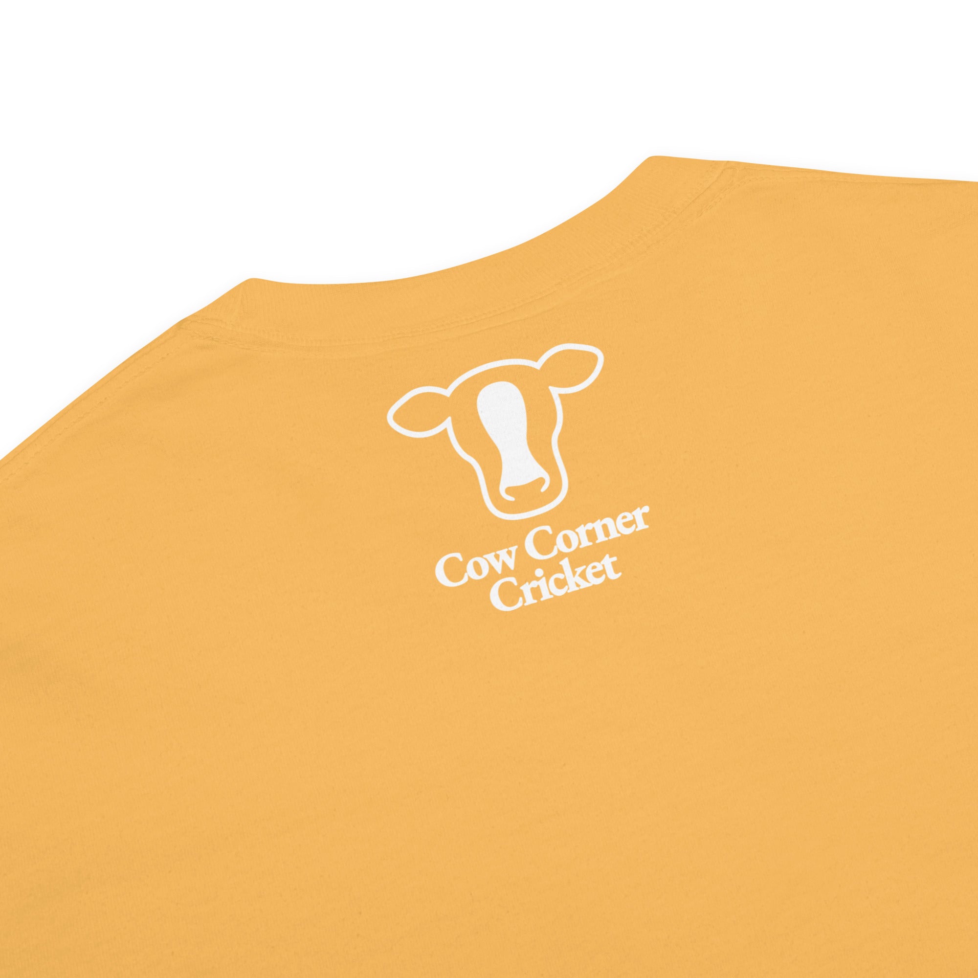 Close-up of a mustard yellow t-shirt with a circular graphic logo on the chest.