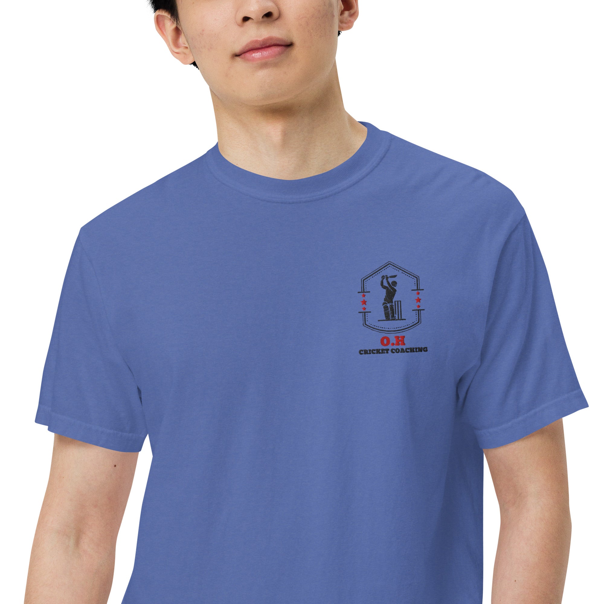 Person wearing a blue t-shirt with a logo on the chest against a white background