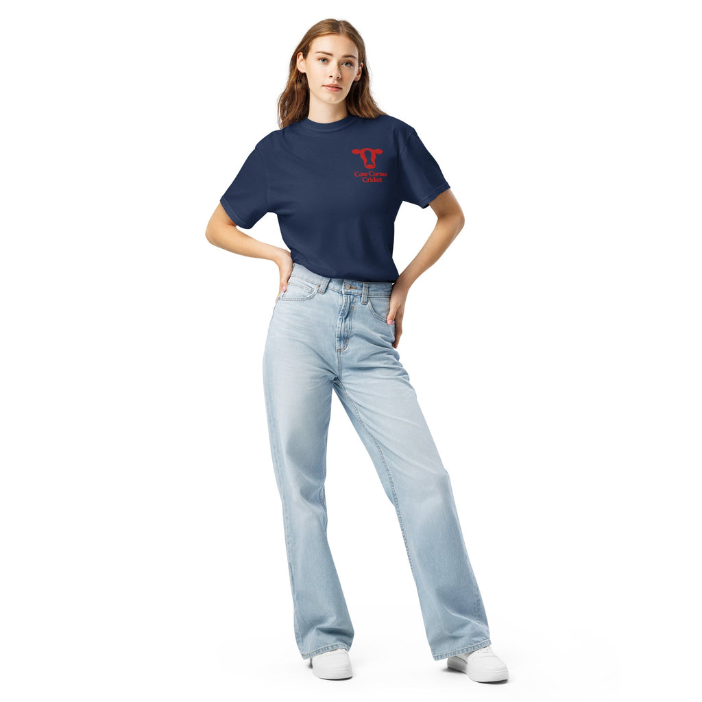 Woman wearing a navy blue t-shirt and light blue jeans with cow corner cricket logo