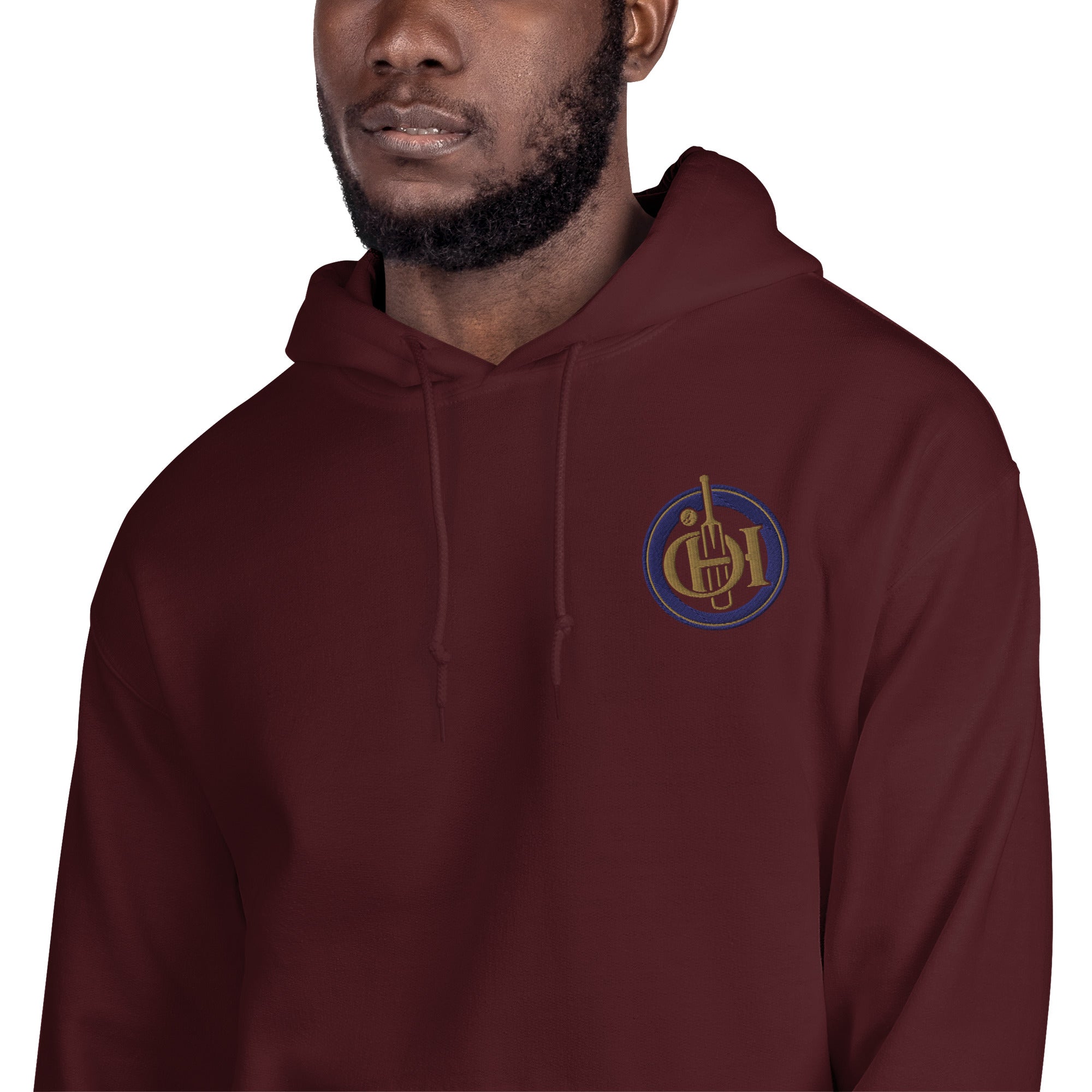 A man wearing a maroon pullover hoodie with a circular embroidered chest logo.