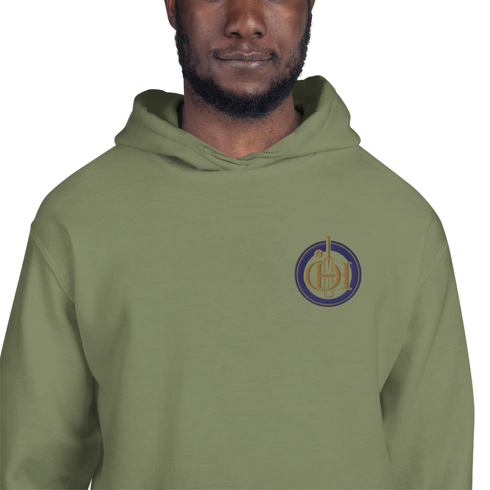A man wearing green pullover hoodie with a circular chest graphic featuring a gold and blue design.