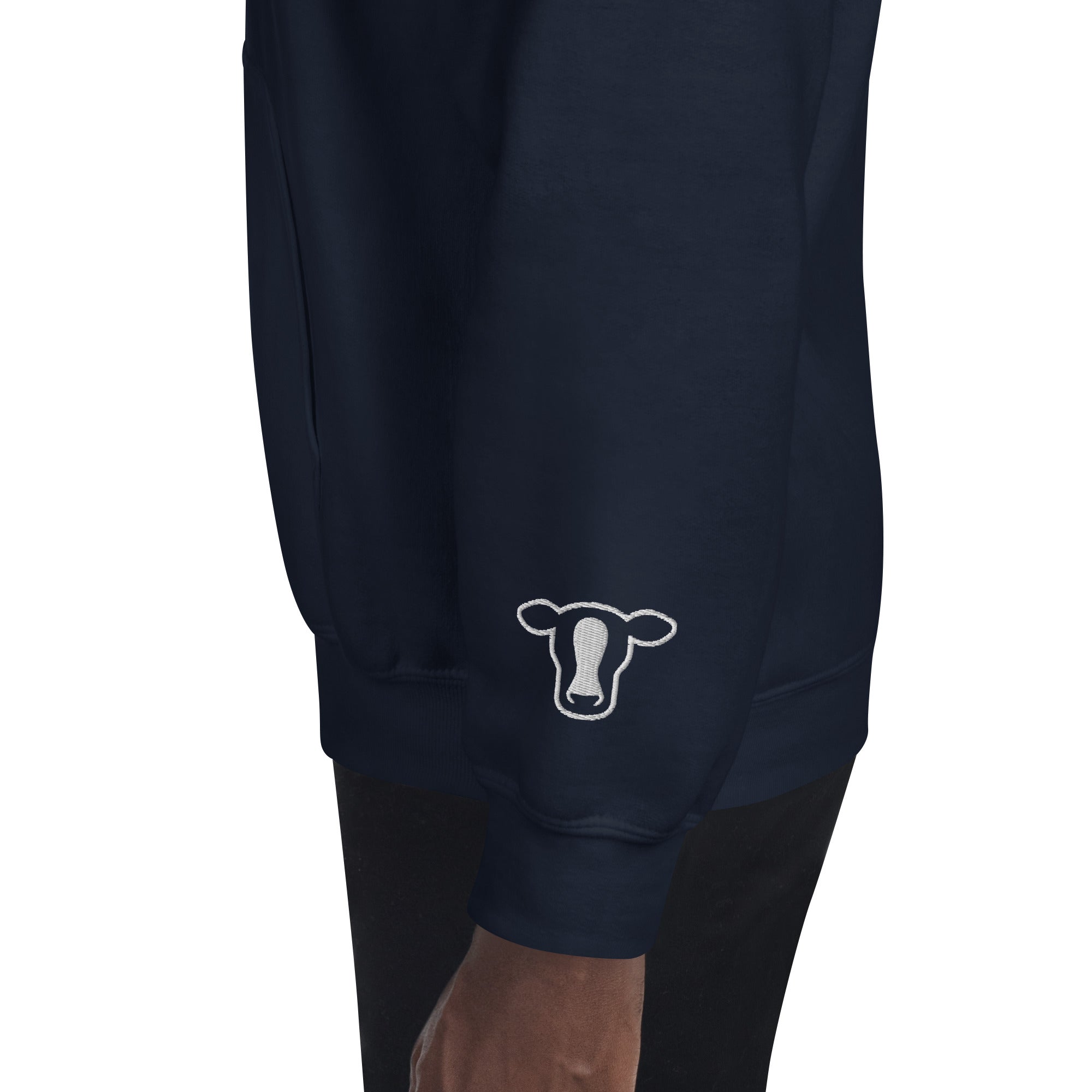 Blue sweatshirt worn by a model, featuring a white outline cow graphic on the left sleeve