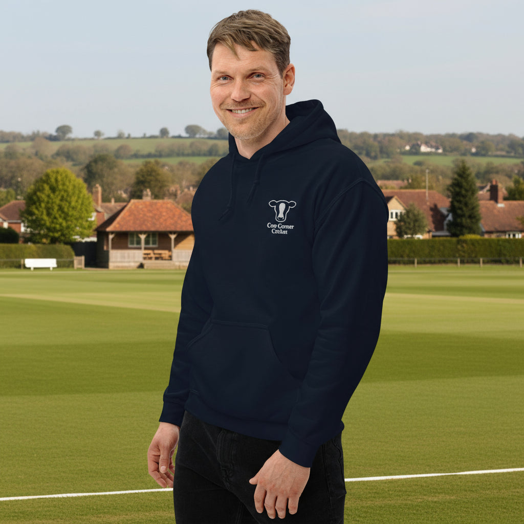 Man wearing a navy hoodie with a logo on a sports field