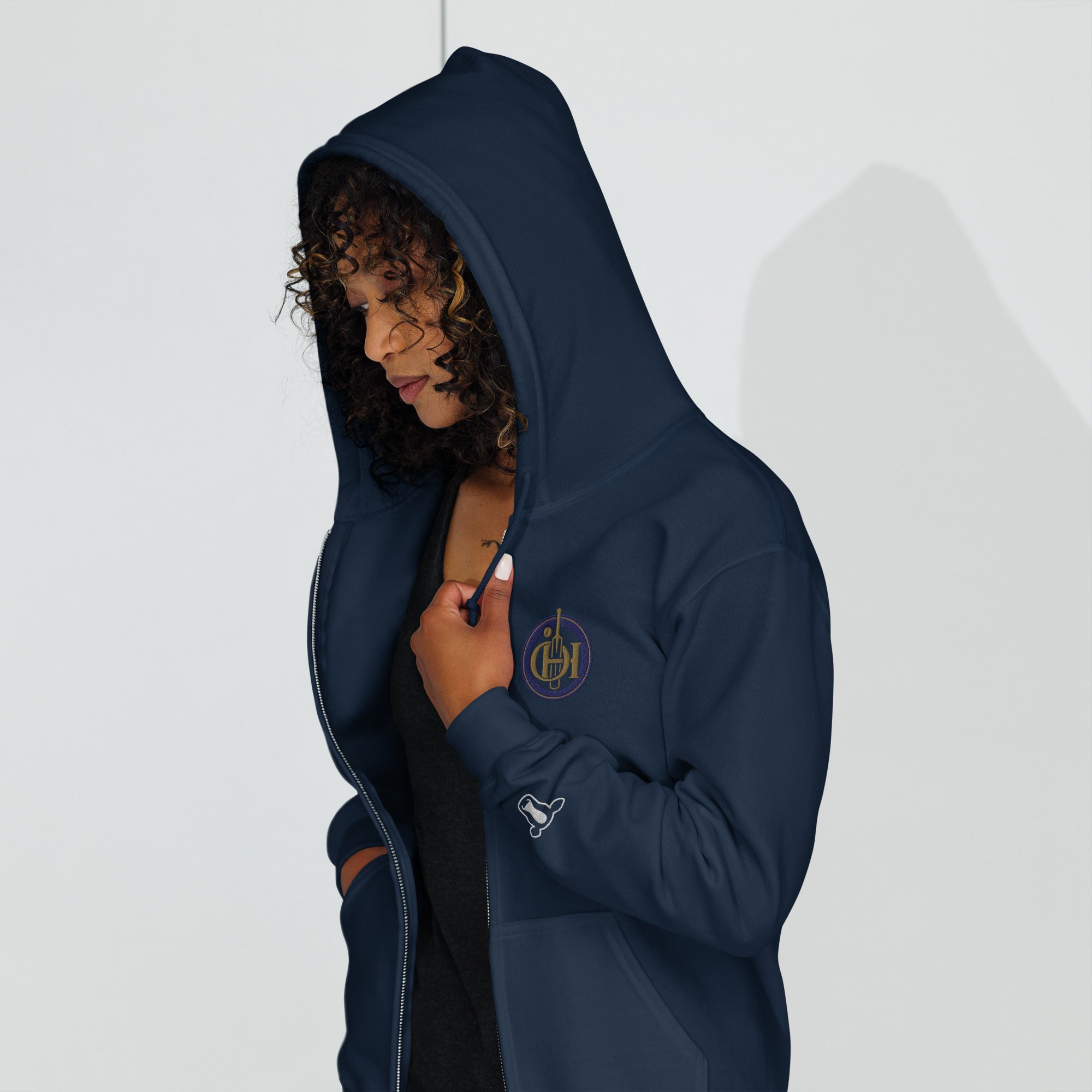 Person wearing a navy blue hoodie with a brand logo on a white background