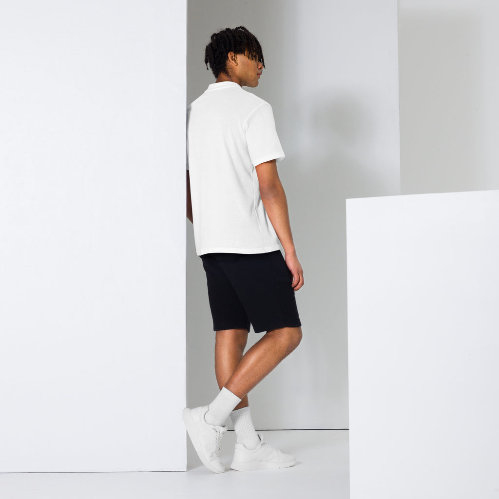 Person wearing a white polo shirt, black shorts, and white sneakers
