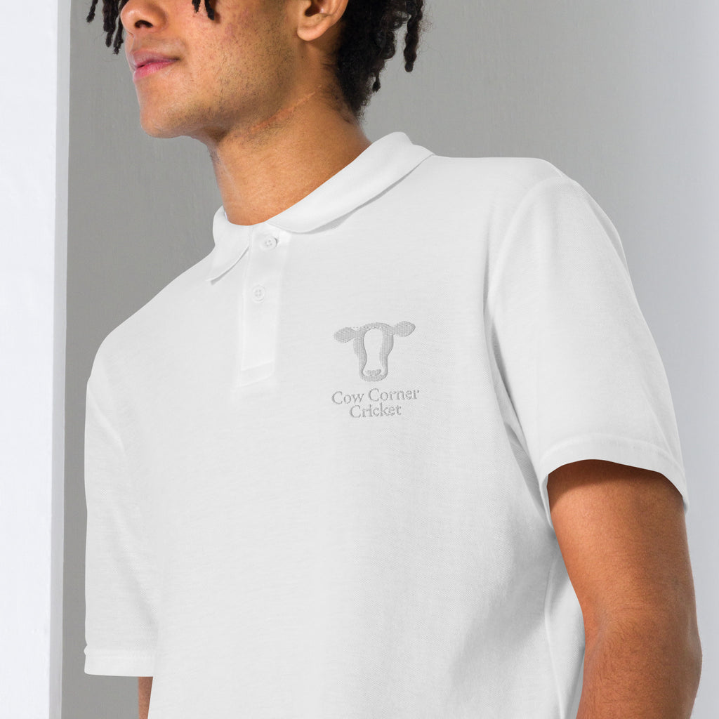 Person wearing a white polo shirt with 'VALTROLUMIN' branding and Cow corner cricket logo